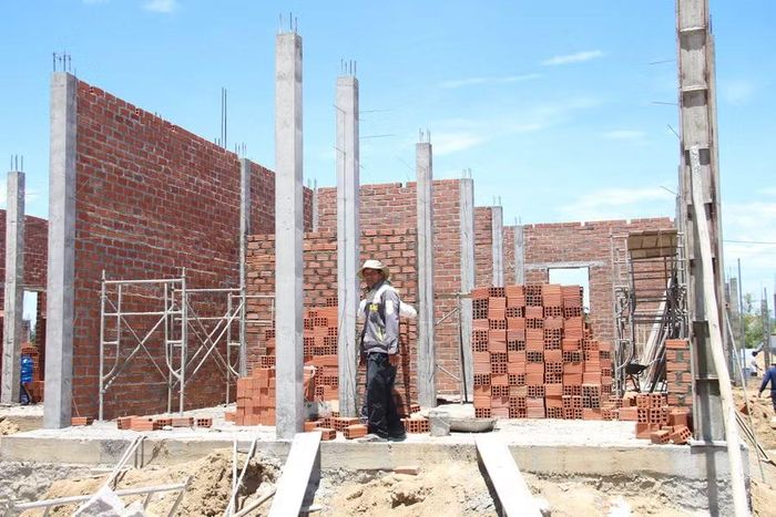 Ông Mai Phu (thôn Đức Phổ, xã Đề Gi) xây nhà tại khu tái định cư. Ảnh: T.Lợi