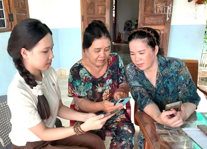Chị Lưu Thị Thanh Liền (bìa trái) hướng dẫn người dân cập nhật các tiện ích số.