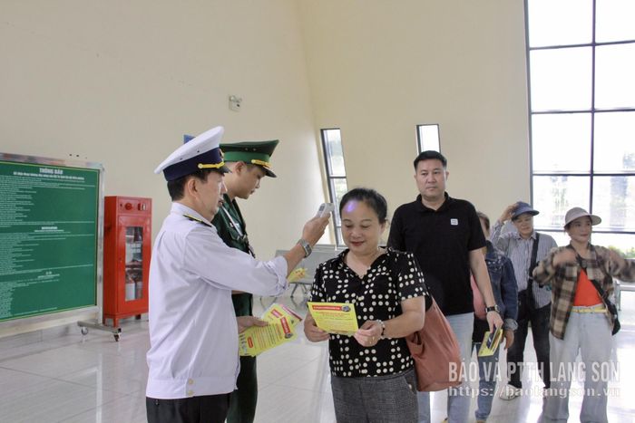 Cán bộ Tổ Kiểm dịch y tế Cửa khẩu Quốc tế Hữu Nghị tuyên truyền và kiểm tra thân nhiệt của người nhập cảnh