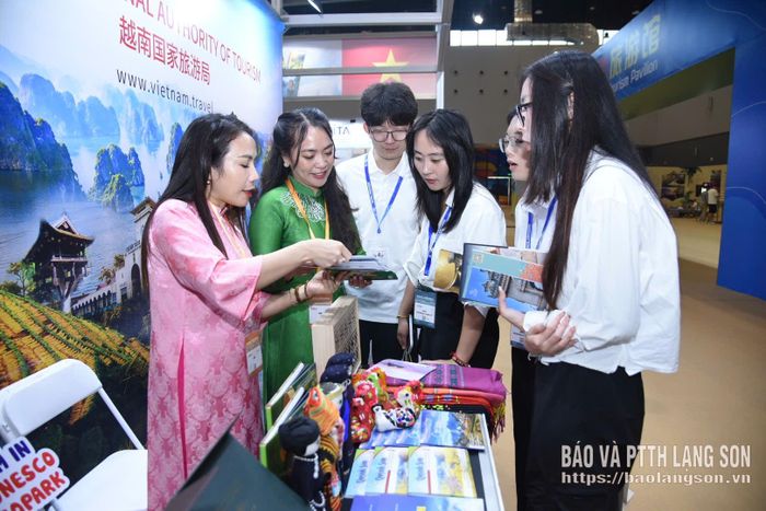 Thành viên đoàn công tác giới thiệu tới du khách các ấn phẩm về du lịch Lạng Sơn tại gian trưng bày