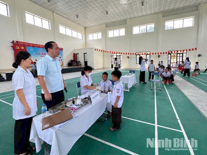 Cán bộ, y bác sĩ Trạm Y tế xã Yên Mô kiểm tra sức khỏe đầu năm học cho các em học sinh trên địa bàn.