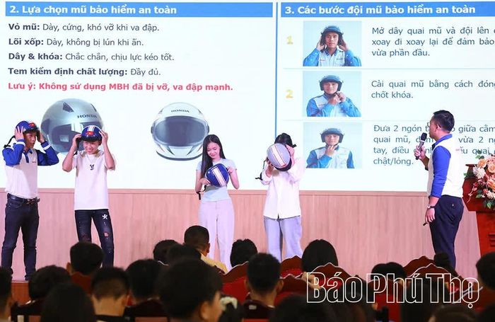 Đại diện Hệ thống HEAD Anh Kỳ hướng dẫn học sinh đội mũ bảo hiểm đúng cách.