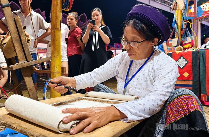 Chị Hà Thị Phờ, thành viên Hợp tác xã Lùng Tám, trình diễn kỹ thuật vẽ sáp ong tạo hoa văn trên vải lanh.