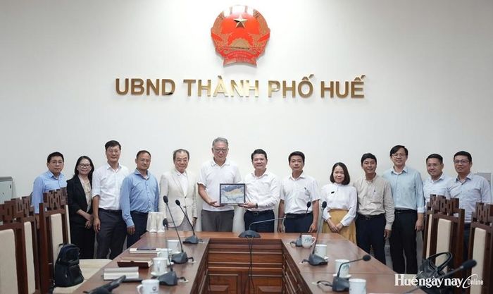 Phó Chủ tịch UBND thành phố Hoàng Hải Minh tặng quà và chụp ảnh lưu niệm với đoàn công tác. 