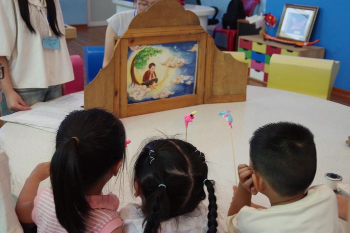 Các em nhỏ say sưa nghe kể chuyện tranh về sự tích Trung thu