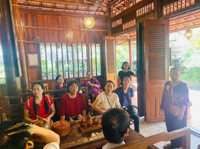 Du khách ngồi nghe bác chủ nhà giới thiệu về ngôi nhà dừa
