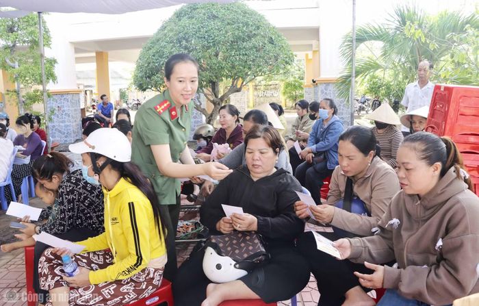 Cán bộ Phòng An ninh mạng phát tờ rơi cho phụ huynh về biện pháp bảo vệ trẻ em trước các thủ đoạn thao túng “bắt cóc online”.
