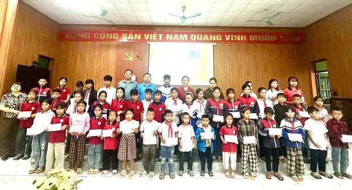 Ban tổ chức trao quà cho học sinh vượt khó tại xã Vân Sơn.