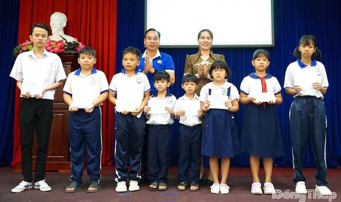 Ban tổ chức trao học bổng cho học sinh nghèo vượt khó. Ảnh: Báo Đồng Tháp