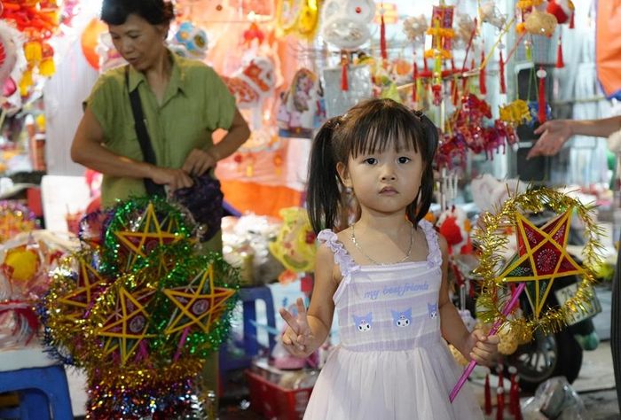 Các em bé háo hức khoe những món đồ chơi đủ sắc màu được bố mẹ mua cho - một hình ảnh quen thuộc mỗi mùa Trung thu trên phố Hàng Mã.