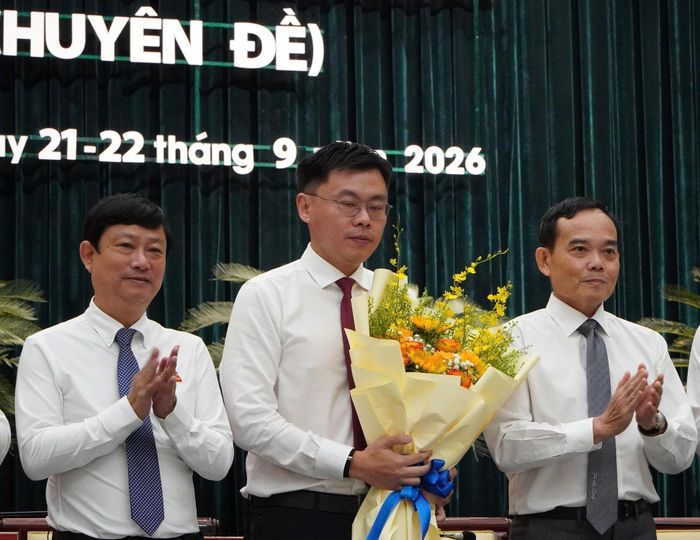 Bí thư Thành ủy Trần Lưu Quang và Chủ tịch HĐND TP.HCM Võ Văn Minh tặng hoa chúc mừng Phó Chủ tịch UBND TP Trương Minh Huy Vũ.