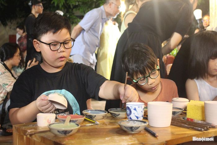 Nhiều em nhỏ hào hứng khám phá kỹ thuật trang trí gốm truyền thống, đồng thời cảm nhận sự tinh tế được tích lũy qua nhiều thế hệ người thợ Bát Tràng.