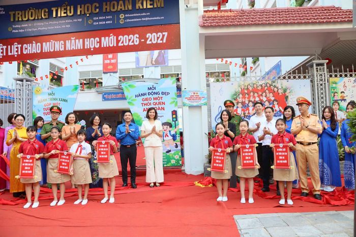 Các đại biểu thực hiện nghi thức ra mắt công trình “Cổng trường an toàn giao thông xanh - Gương sáng dẫn đường” tại Trường Tiểu học Hoàn Kiếm. Ảnh: PV