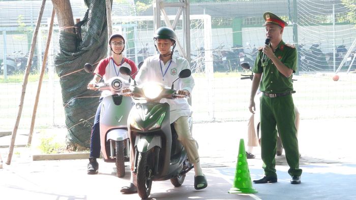 Học sinh thực hành kỹ năng tham gia giao thông an toàn dưới sự hướng dẫn của cán bộ Công an. Ảnh: Đỗ Duẩn