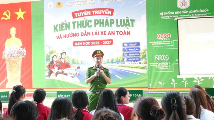 Cán bộ Công an phường Dương Nội tuyên truyền pháp luật về trật tự, an toàn giao thông cho học sinh. Ảnh: Đỗ Duẩn