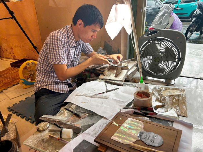 Các nghệ nhân làng nghề Chuyên Mỹ làm sản phẩm sơn mài. Ảnh: K.H