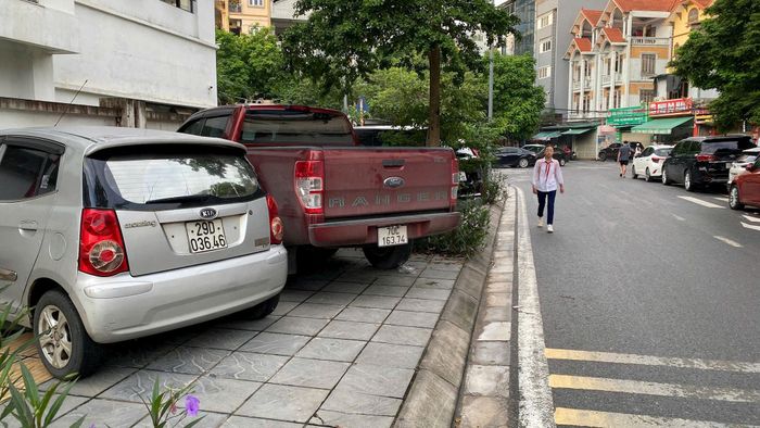 Vỉa hè bị bịp kín đẩy học sinh phải đi bộ dưới lòng đường. Ảnh: NS