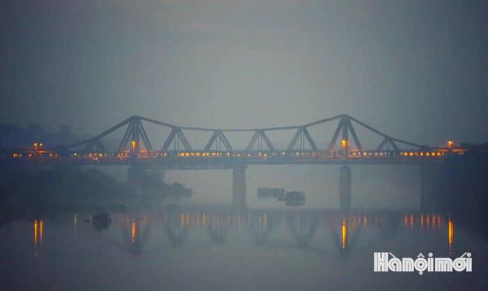 Trong ánh bình minh đầu ngày, cầu Long Biên hiện lên trầm mặc, cổ kính giữa không gian còn bảng lảng hơi sương. Ảnh: NAG Nguyễn Quốc Vượng