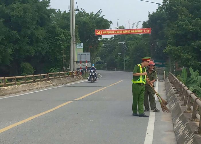 Công an xã Hát Môn ra quân vệ sinh môi trường trên tuyến đường "Ba nhất". Ảnh: HM
