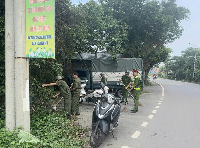 Lực lượng chức năng dọn vệ sinh, phát quang bụi rậm, bảo đảm thông thoáng, sạch sẽ lòng và lề đường. Ảnh: HM