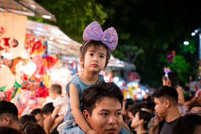  Nhiều thời điểm, con phố không còn khoảng trống để di chuyển, nhiều em nhỏ được phụ huynh cõng trên vai để tránh đi lạc. 