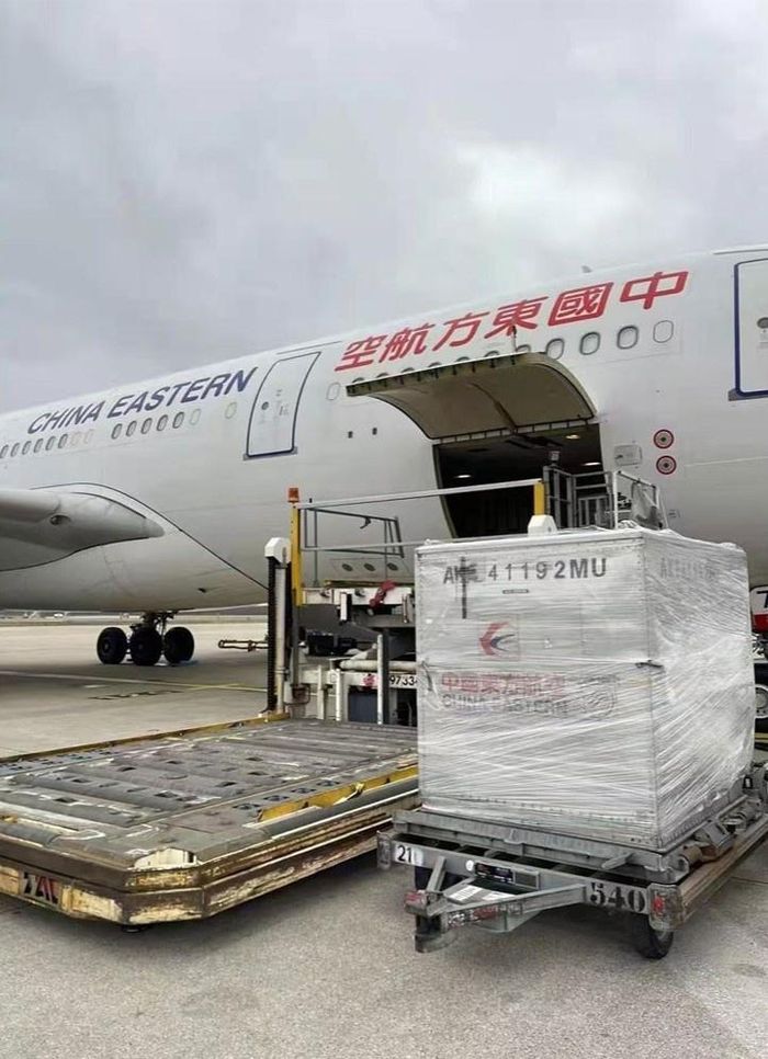 (Ảnh trái) Các công nhân chuẩn bị vận chuyển chiếc hộp gia cố bằng nhôm đựng hai tập Vĩnh Lạc đại điển đến sân bay ở Paris (Pháp) năm 2021; (Ảnh phải) Hai tập bách khoa toàn thư đã hạ cánh xuống Thượng Hải năm 2021. Ảnh: NVCC/Sixth Tone.