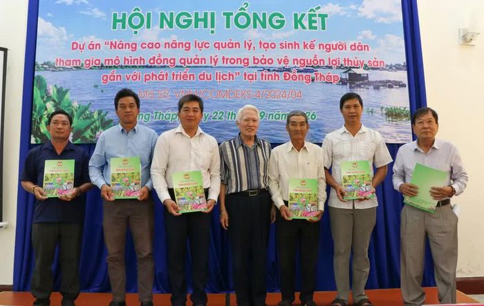 Đại diện các tổ cộng đồng nhận biên bản bàn giao trang thiết bị, vật tư của dự án. Ảnh: Hồng Thái - TTXVN