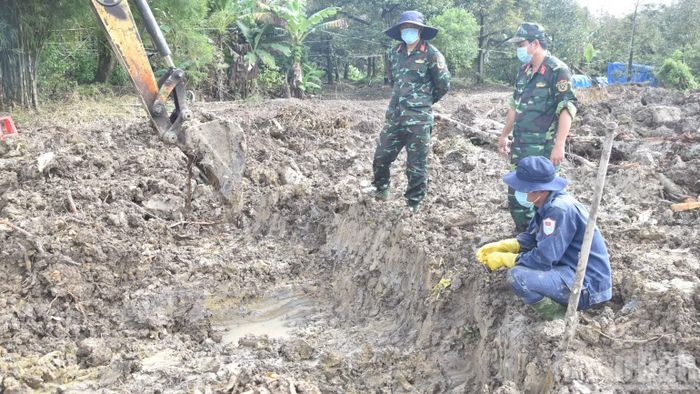 Lực lượng Đội K91 tỉ mỉ tìm đồng đội còn nằm lại ở vườn sầu riêng ở xã Ngũ Hiệp, tỉnh Đồng Tháp. (Ảnh: NGUYỄN SỰ)
