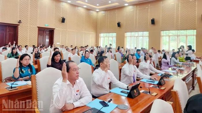 Đại biểu biểu quyết thông qua Nghị quyết Hội đồng nhân dân tỉnh An Giang. (Ảnh: QUỐC TRINH)