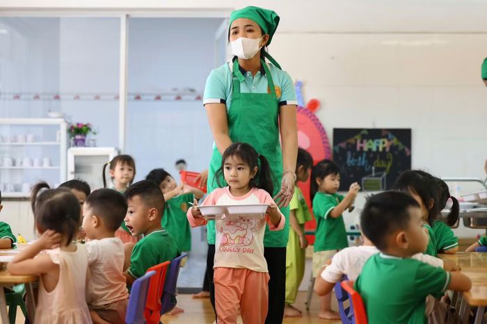 Nhân viên nhà bếp phục vụ bữa ăn cho các em học sinh Trường mầm non Bông Sen, xã Đông Thạnh. (Ảnh: TRỌNG ANH)