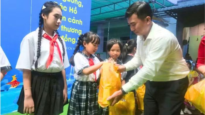 Đồng chí Lý Hùng Em, Bí thư Đảng ủy xã Hòa An, thành phố Cần Thơ tặng quà các em thiếu nhi. (Ảnh: VĂN ÚT)