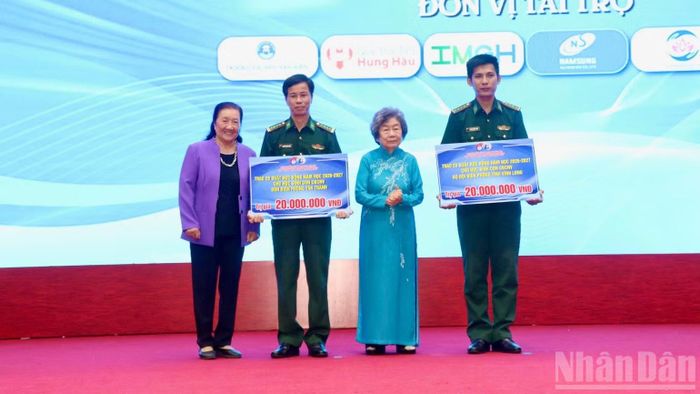 Đại diện Bộ đội Biên phòng tỉnh Đồng Tháp và Vĩnh Long nhận bảng tượng trưng học bổng cho con em. (Ảnh: NGUYỄN SỰ)