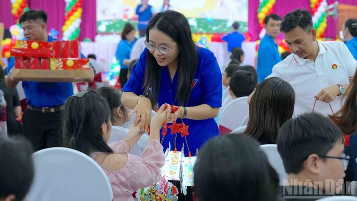 Đại diện lãnh đạo Tỉnh đoàn Cà Mau tặng quà cho các cháu thiếu nhi là con công nhân, viên chức, lao động tại buổi họp mặt. (Ảnh: HỮU TÙNG)