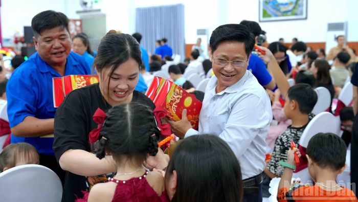 Phó Chủ tịch Hội đồng nhân dân tỉnh Bùi Tấn Bảy (đứng bên phải) trao quà Trung thu cho các cháu thiếu nhi tại buổi họp mặt. (Ảnh: HỮU TÙNG)