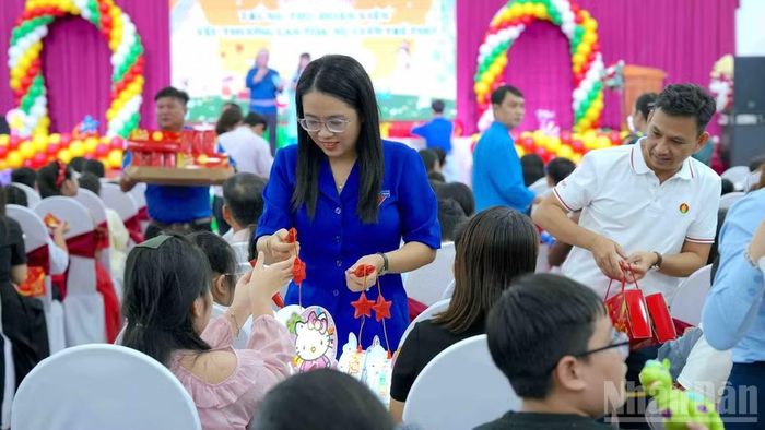 Tặng quà cho các cháu thiếu nhi là con công nhân, viên chức, lao động tại buổi họp mặt. (Ảnh: HỮU TÙNG)