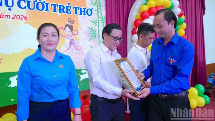 Bí thư Tỉnh đoàn Cà Mau Phạm Tuấn Tài (bìa phải) tặng giấy chứng nhận cảm ơn các đơn vị Công đoàn cơ sở đồng hành cùng chương trình họp mặt. (Ảnh: HỮU TÙNG)