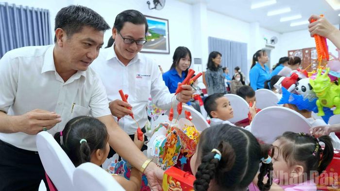Đại diện đoàn thể tỉnh Cà Mau trao tặng quà cho các cháu thiếu nhi. (Ảnh: HỮU TÙNG)
