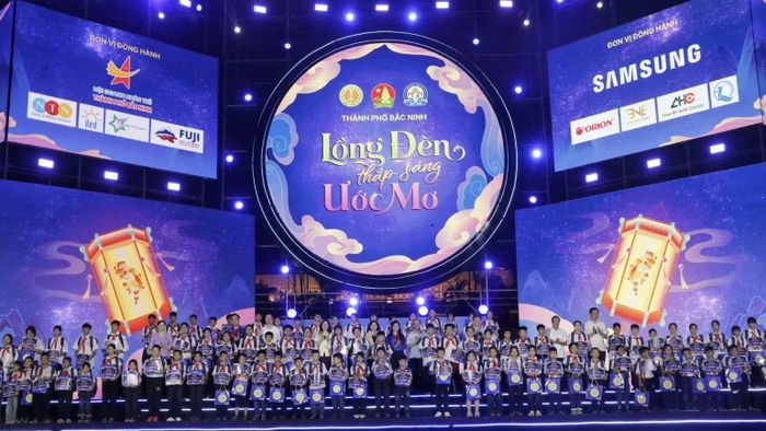 100 suất học bổng đỡ đầu “Nâng bước em đến trường” dành tặng 100 em học sinh nghèo vượt khó học giỏi được trao tại chương trình. ( Ảnh: A.T).