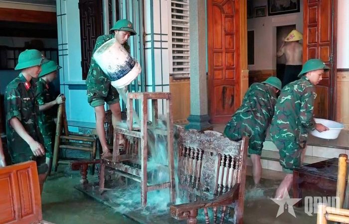 Đồ đạc được bộ đội hỗ trợ lau rửa, kê kích lại sau khi lũ rút.