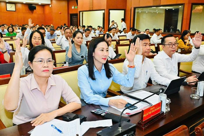 Đại biểu biểu quyết thông qua nội dung chương trình hội nghị. Ảnh: VIỆT DŨNG