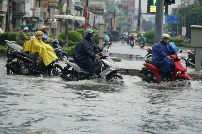 Người đi xe máy gặp nhiều khó khăn khi vừa phải tránh các điểm ngập, vừa di chuyển trong dòng phương tiện đông đúc. Trong ảnh: Đường Lý Thường Kiệt gần Ngã tư Bảy Hiền đường dường như biến thành sông. Ảnh: KIÊN CƯỜNG
