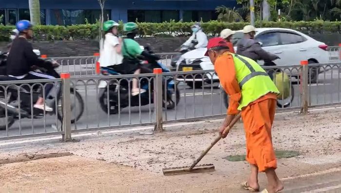 Các công nhân tích cực cào gom, múc bùn đất và huy động xe chuyên dụng xịt rửa mặt đường.