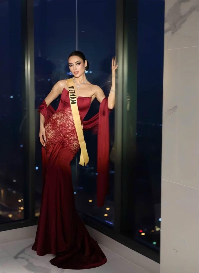 Với váy dạ hội đỏ rượu vang, Emoura Phạm chuyển sang phong cách sang trọng. Thiết kế ôm sát cơ thể, phần choàng dài ở hai tay giúp tôn chiều cao và vóc dáng thanh mảnh của cô.