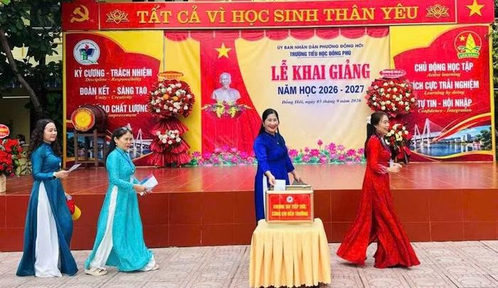 Các cán bộ, giáo viên hưởng ứng chương trình quyên góp ủng hộ học sinh.