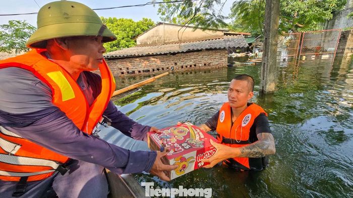 Nhu yếu phẩm được chuyển tới các hộ dân còn bị nước bao quanh sau nhiều ngày.