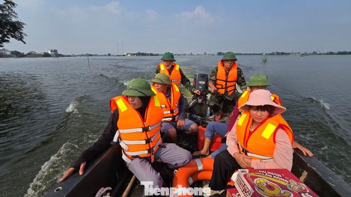 Đại diện thôn Mỹ Lương cùng chính quyền địa phương đi xuồng vào những khu vực còn ngập sâu để kiểm tra tình hình và hỗ trợ người dân.