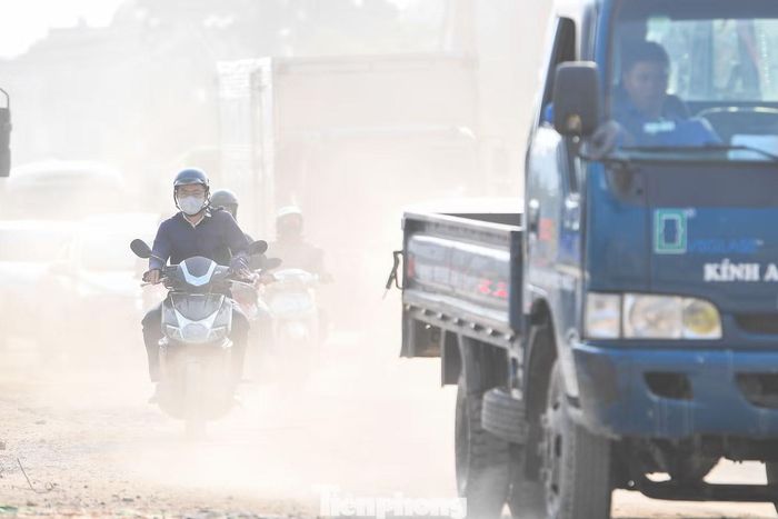 Đất đá, vật liệu xây dựng bị phương tiện cuốn lên, gây bụi tại khu vực công trường và ảnh hưởng đến người đi đường.