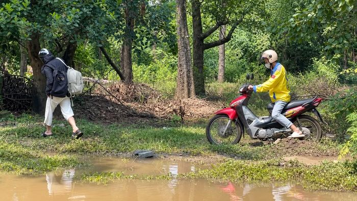 Nhằm né tránh các điểm ngập nước sâu dưới lòng đường, không ít người đi xe máy chọn cách di chuyển lên phần vỉa hè để qua khu vực này.