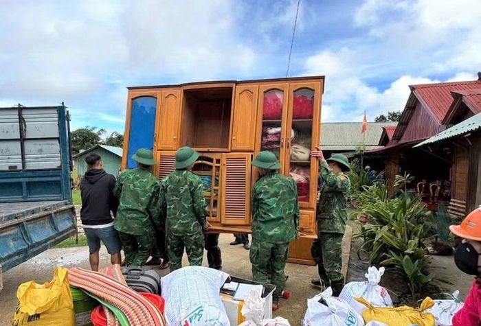 Lực lượng chức năng hỗ trợ người dân di dời khỏi nơi có nguy cơ sạt lở trong bối cảnh mưa lớn.