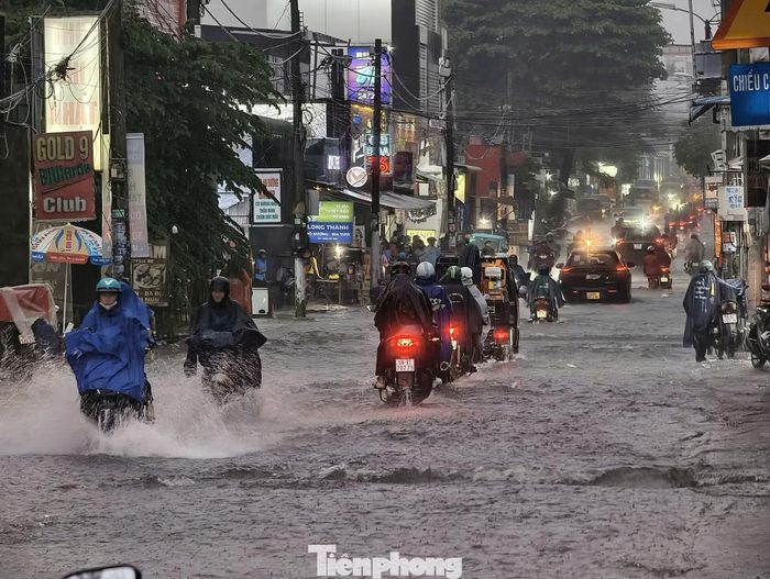 Nhiều người đi xe máy phải chạy sát mép đường, thậm chí leo lên vỉa hè để tránh những đoạn ngập sâu.